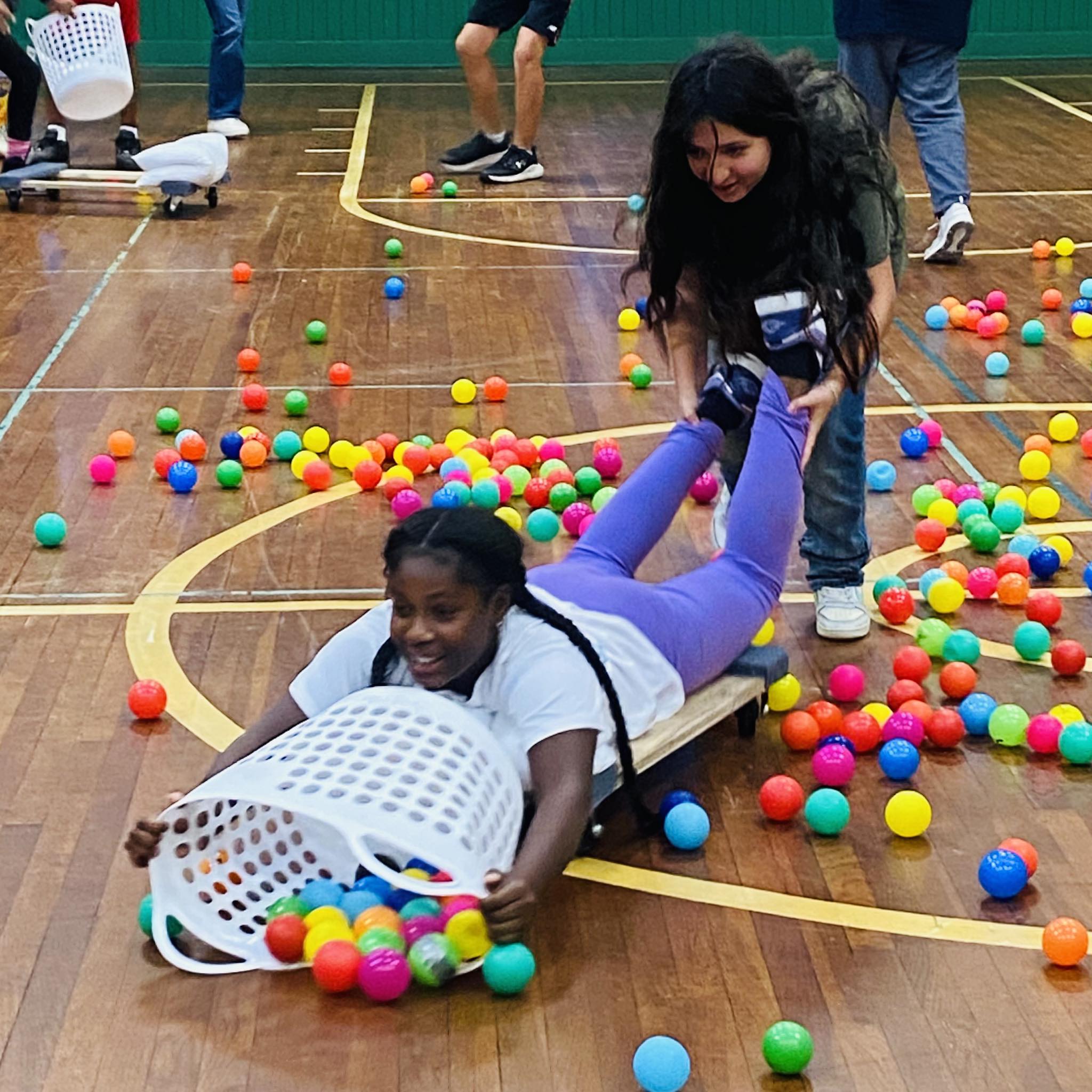 Two girls playing the human version of Hungry, Hungry Hippos.